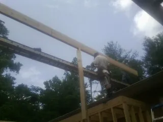 Carpenter setting a ridge beam over a new addition frame — Ice Dam Removal by Roofing Brothers in Marriottsville