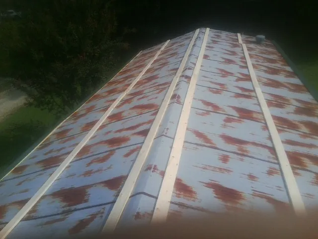Rusted metal roof panels with new wood purlins before replacement — Storm Damage Roof Repair in Marriottsville by Roofing Brothers