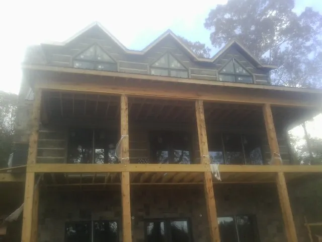 Dormers and porch framing on a large log home under construction — Roof Coating work by our crew in Marriottsville
