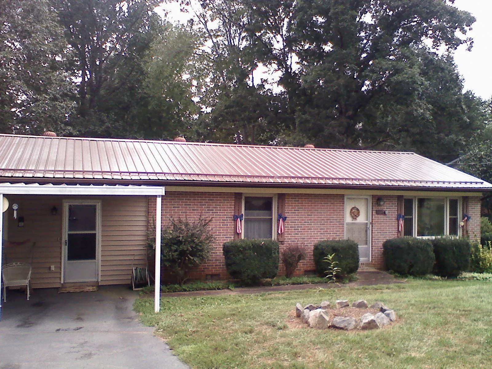 Bronze metal roof and carport on a brick ranch home — Roof Repair work by our crew in Marriottsville