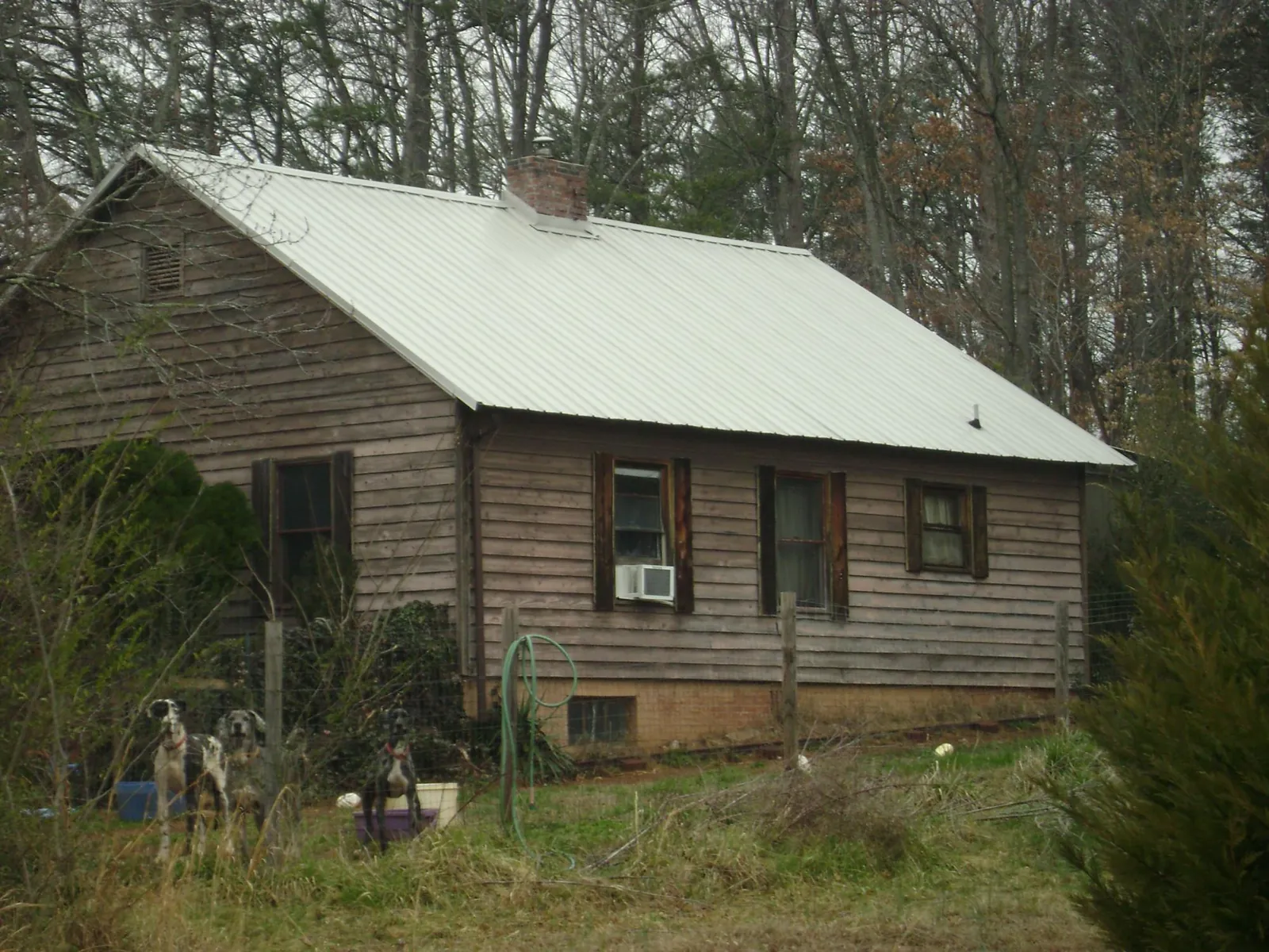 White metal roof on an old wood sided farmhouse, from a Asphalt Shingle Roof Repair job in Marriottsville